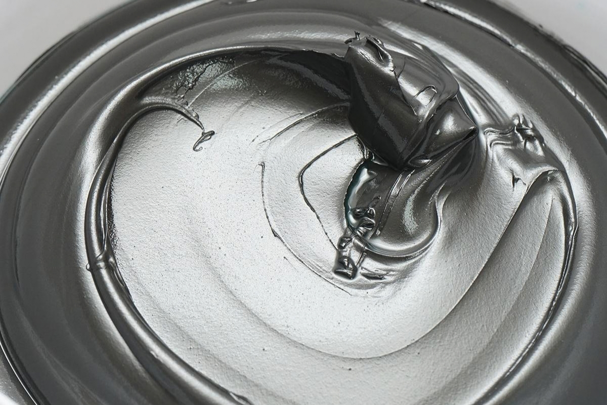 Grey lubricant paste in a round metal container
